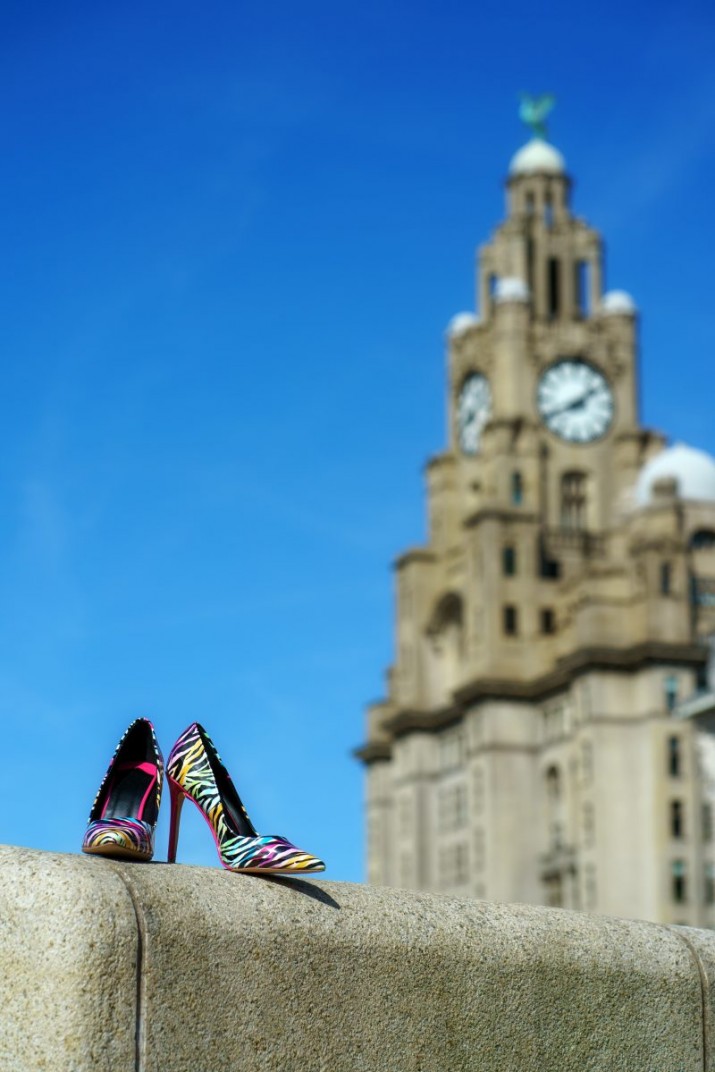 Liverpool liver building with pair of multi-coloured high heeled shoes in foreground